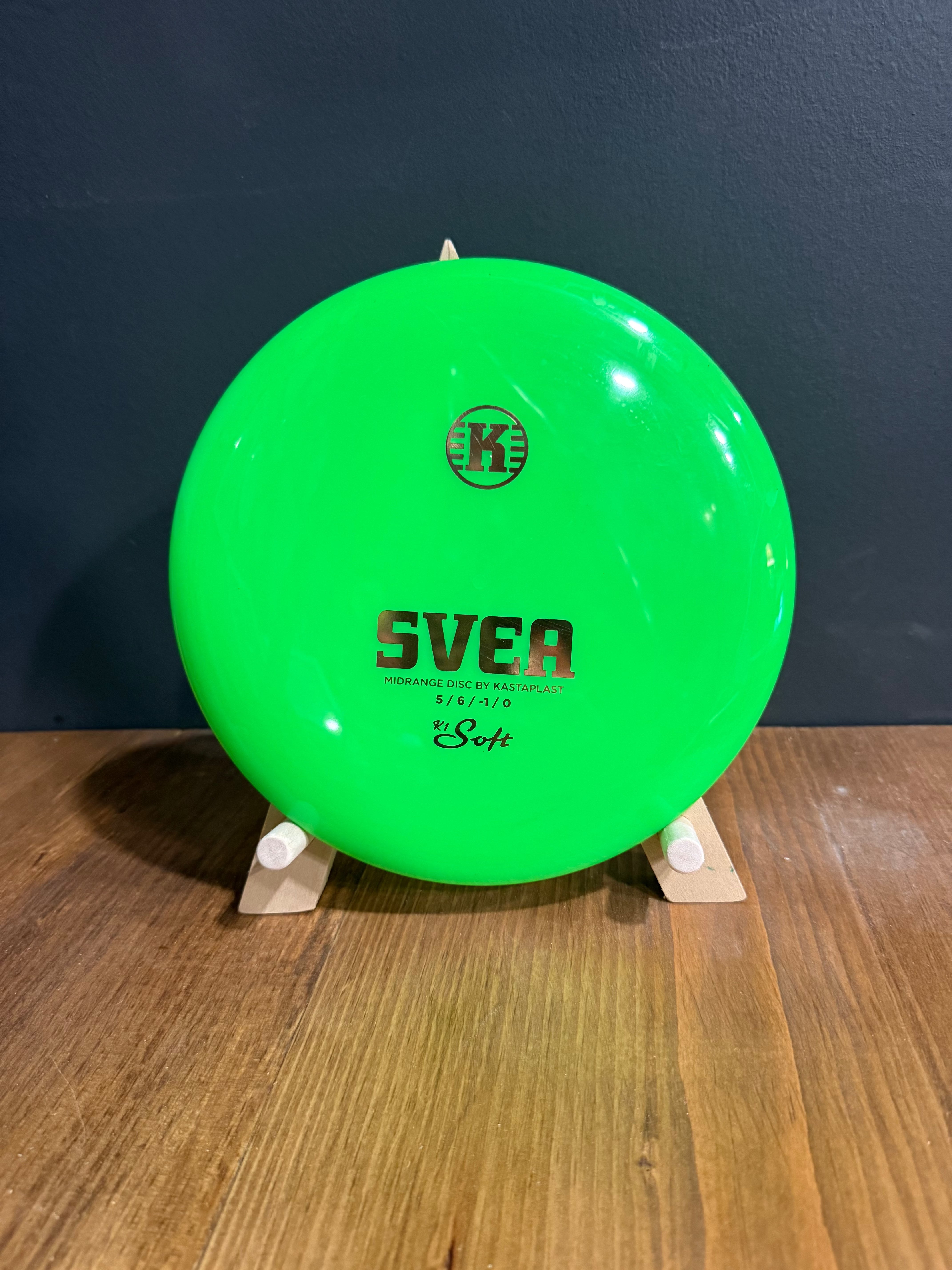 K1 Svea disc in bright neon green plastic, featuring black Svea branding and a compact low-profile design