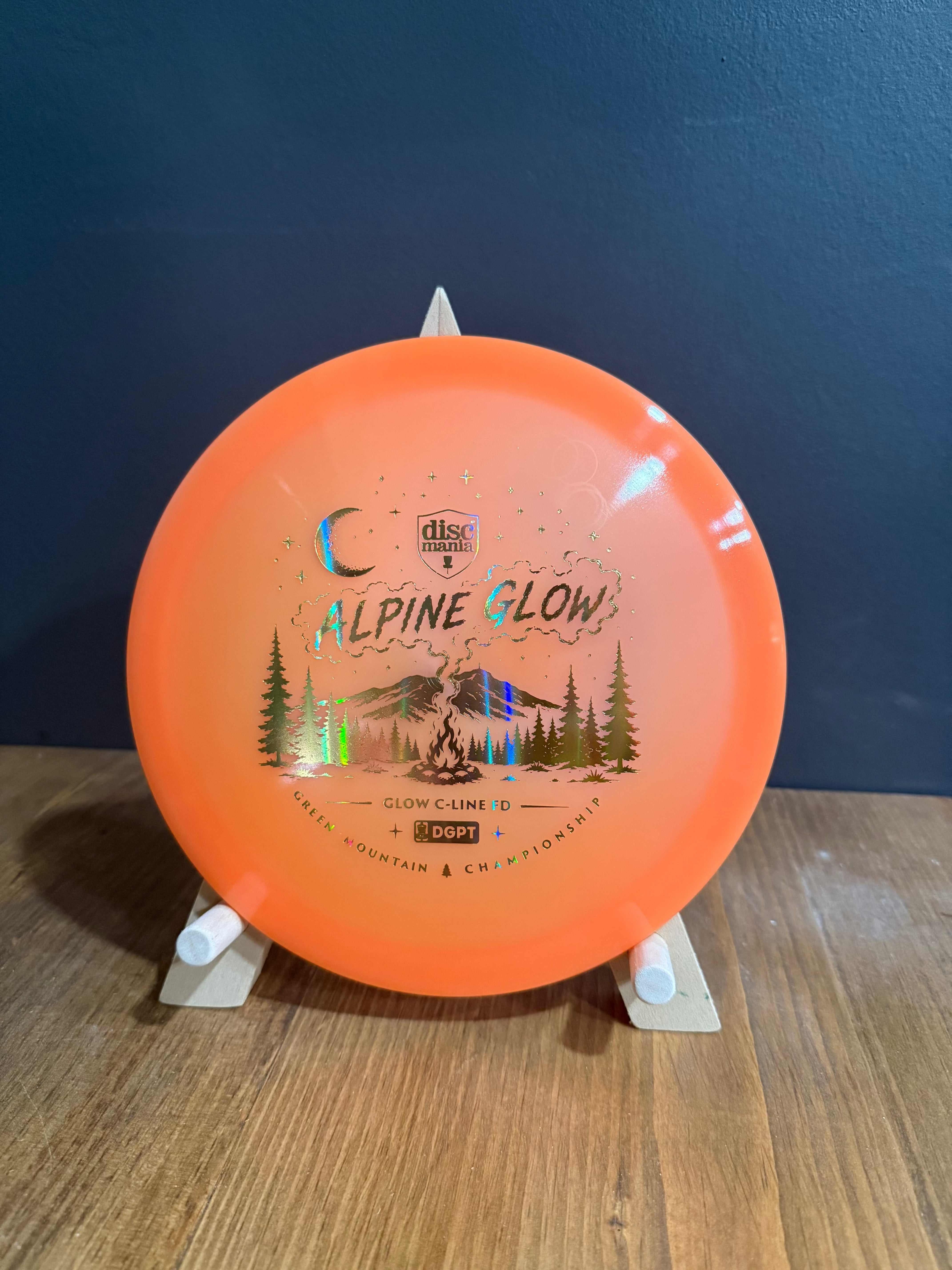 Alpine Glow orange Glow C-Line FD disc with a mountain landscape graphic and metallic stamp detail