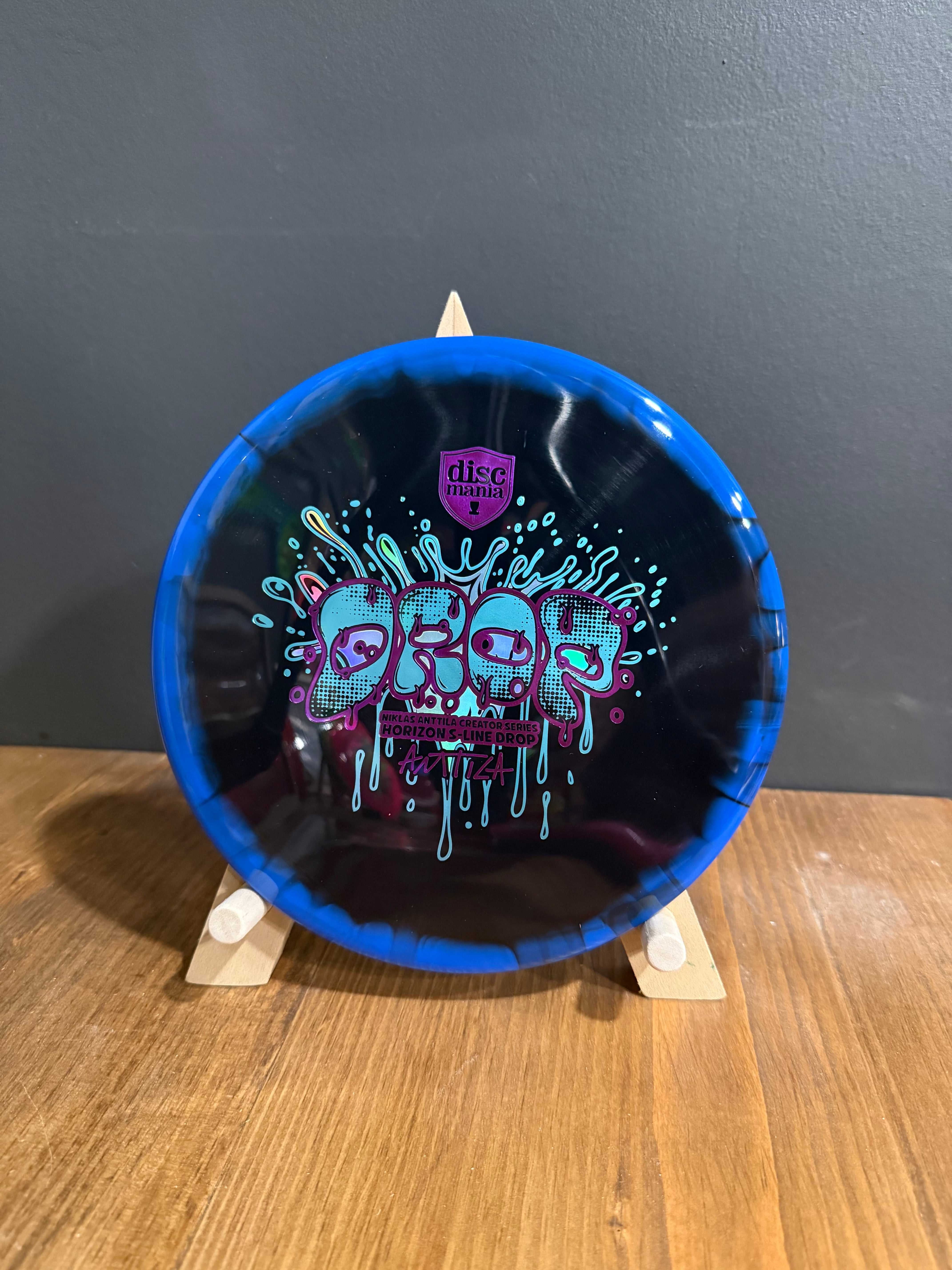 Disc golf putter in blue and black premium plastic, featuring colourful Niklas Anttila Creator Series stamp