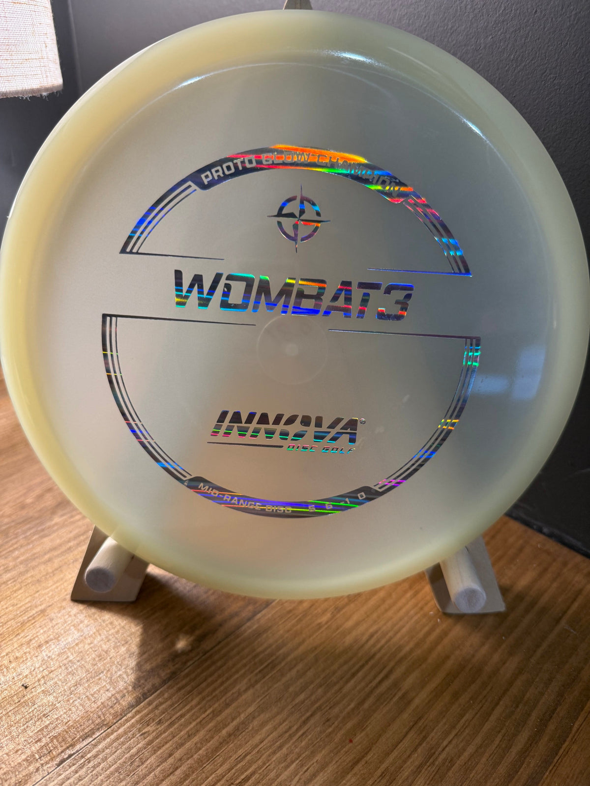Glow translucent disc golf driver with holographic Wombat3 stamp and soft yellow-green rim tint