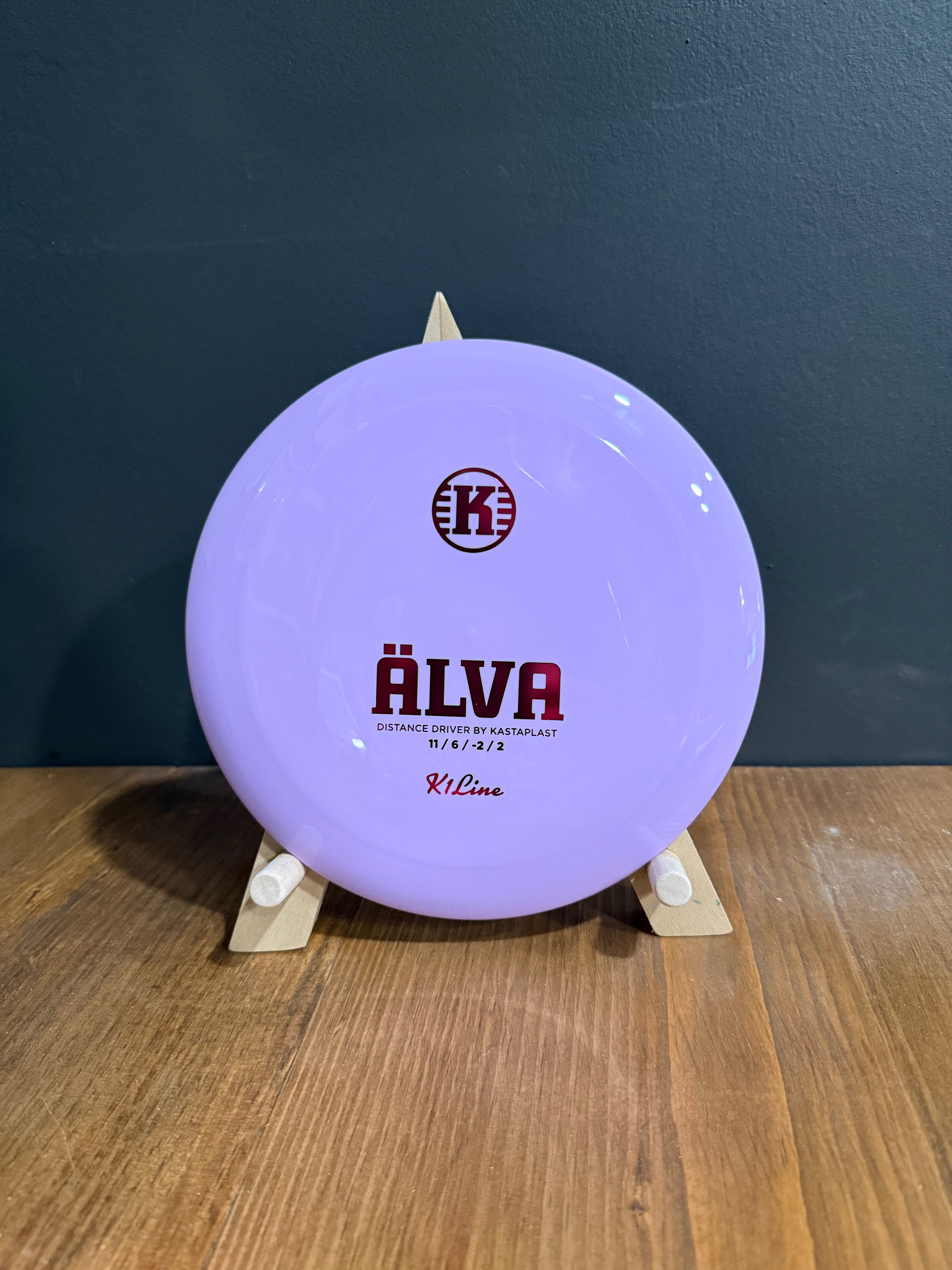 K1 Alva purple plastic disc golf disc with bold burgundy branding and a wide rim for controlled throws