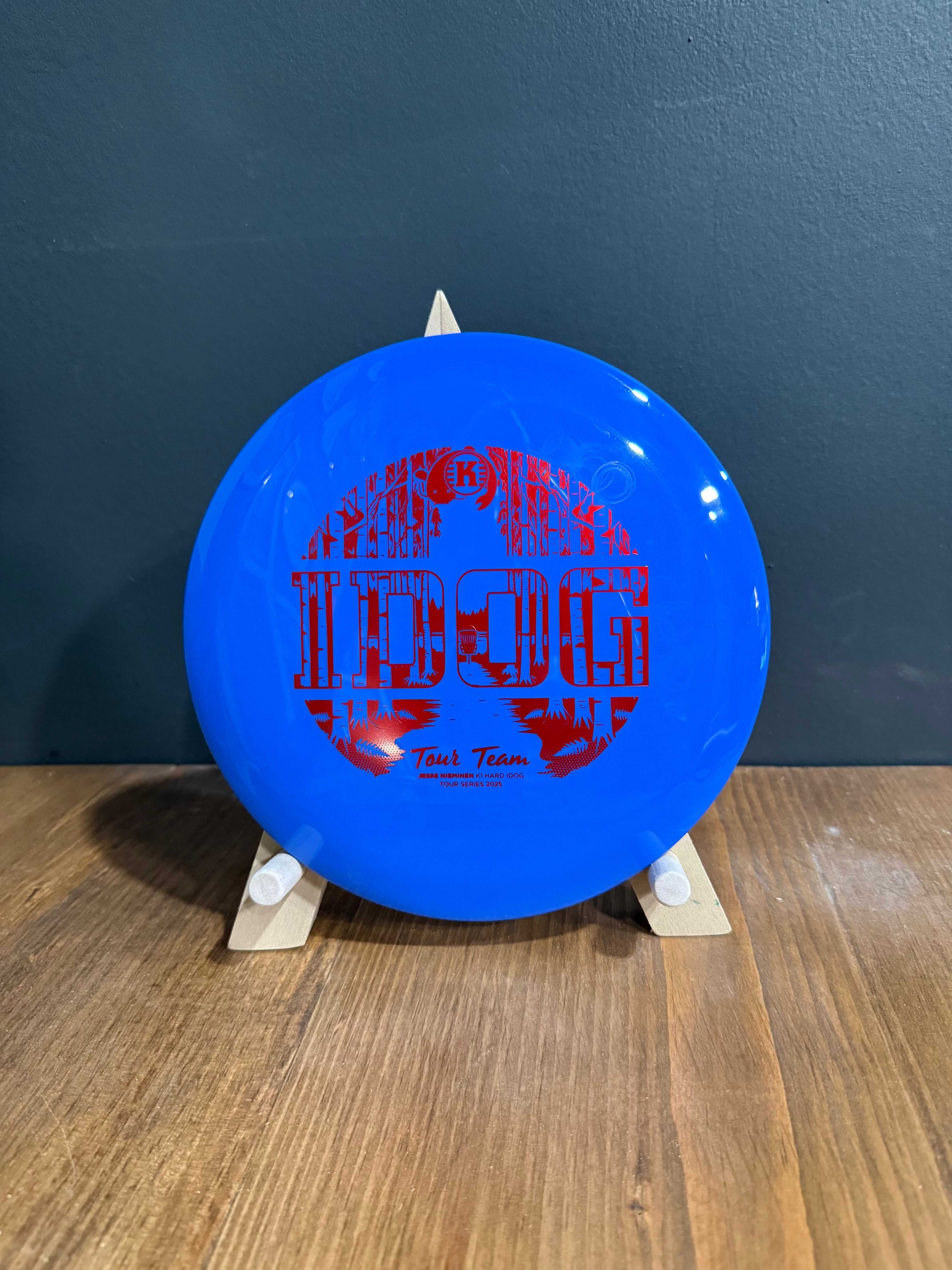 K1 Hard Idog disc in bright blue plastic with bold red Jesse Nieminen Tour Series graphic and lettering