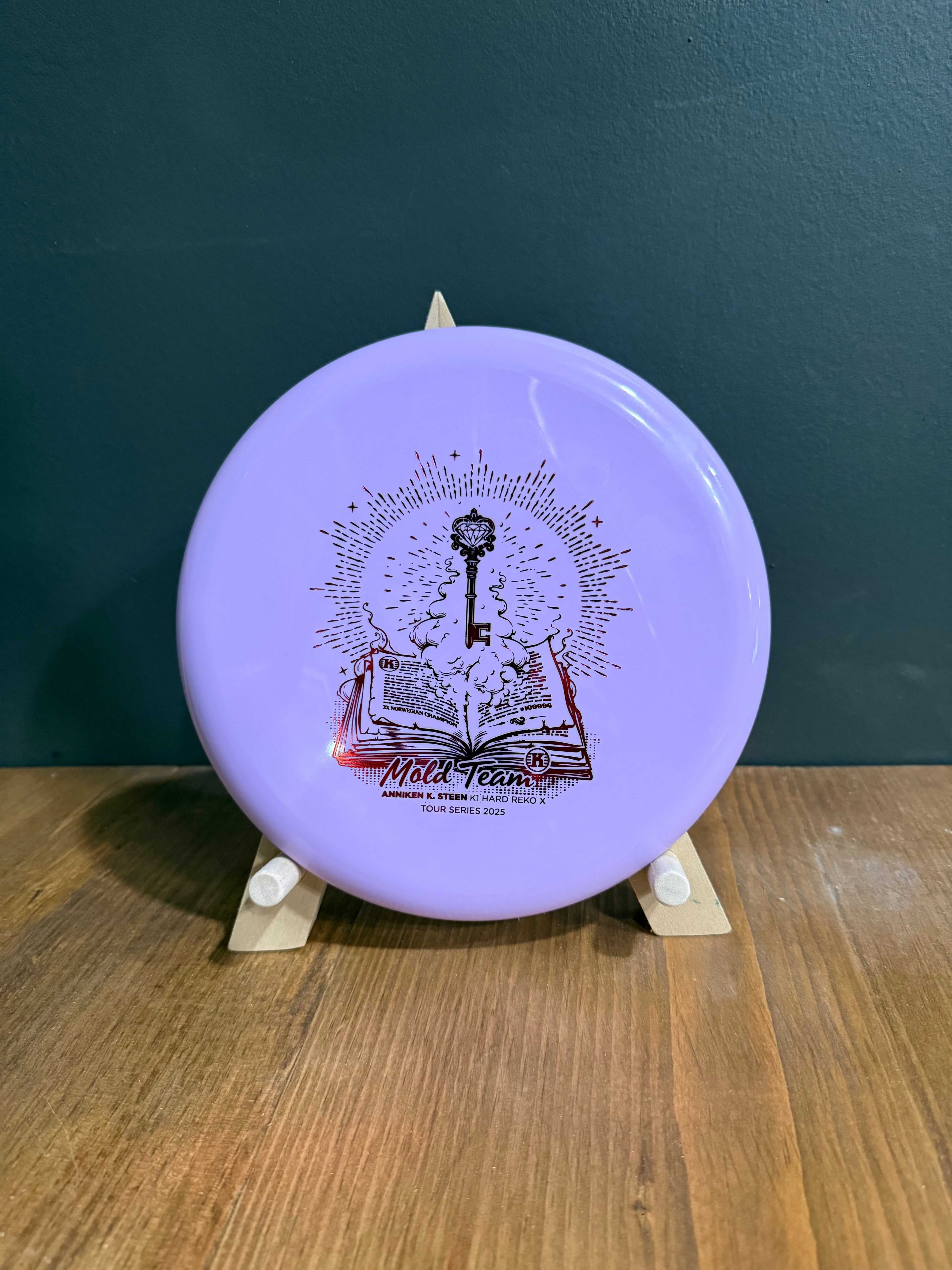 K1 Hard Reko X lavender K1 plastic disc with black Anniken Steen Mold Team artwork and smooth rim