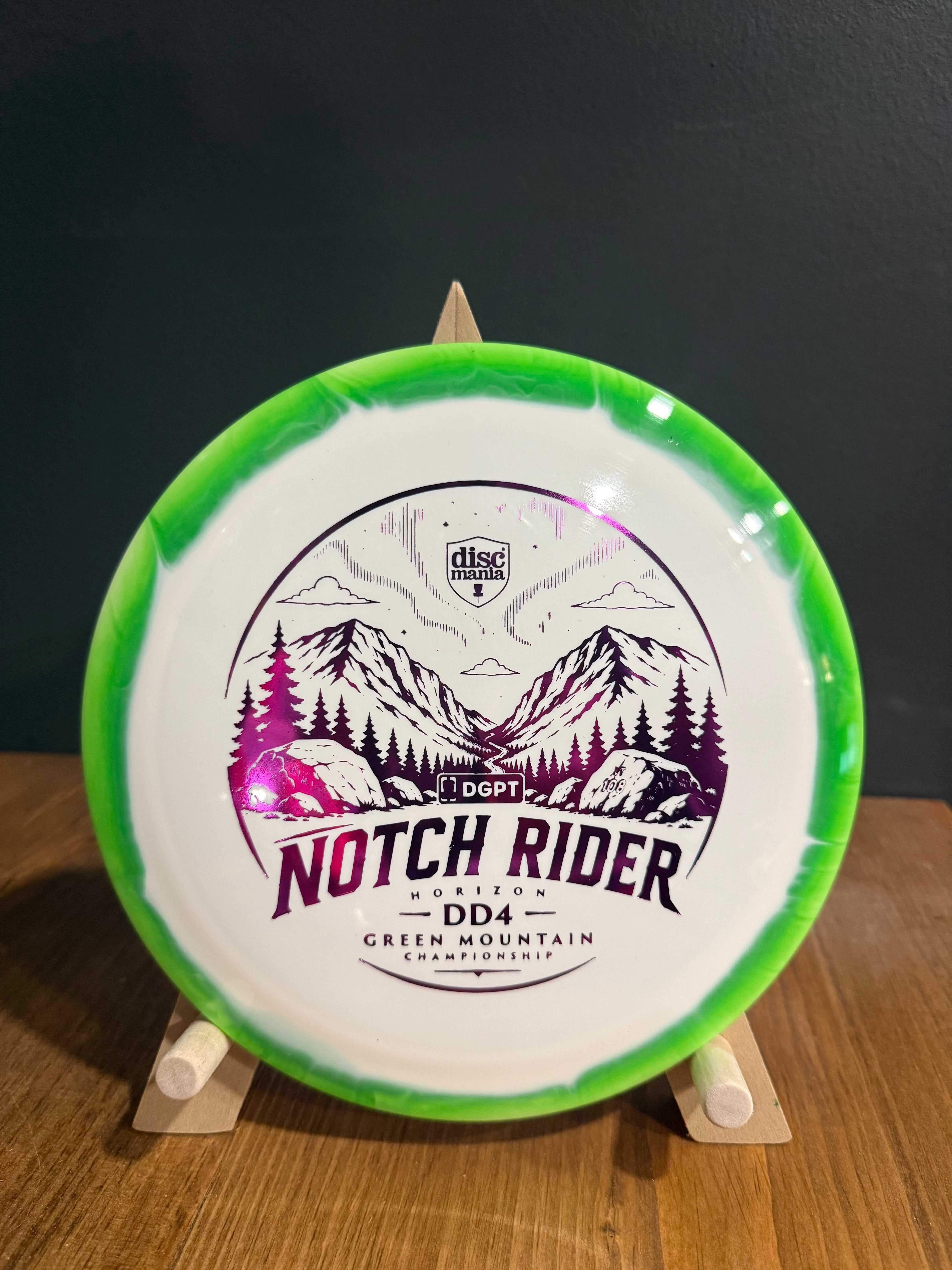 Notch Rider DD4 disc golf driver in white and bright green Horizon S-Line plastic, with mountain artwork and event stamp