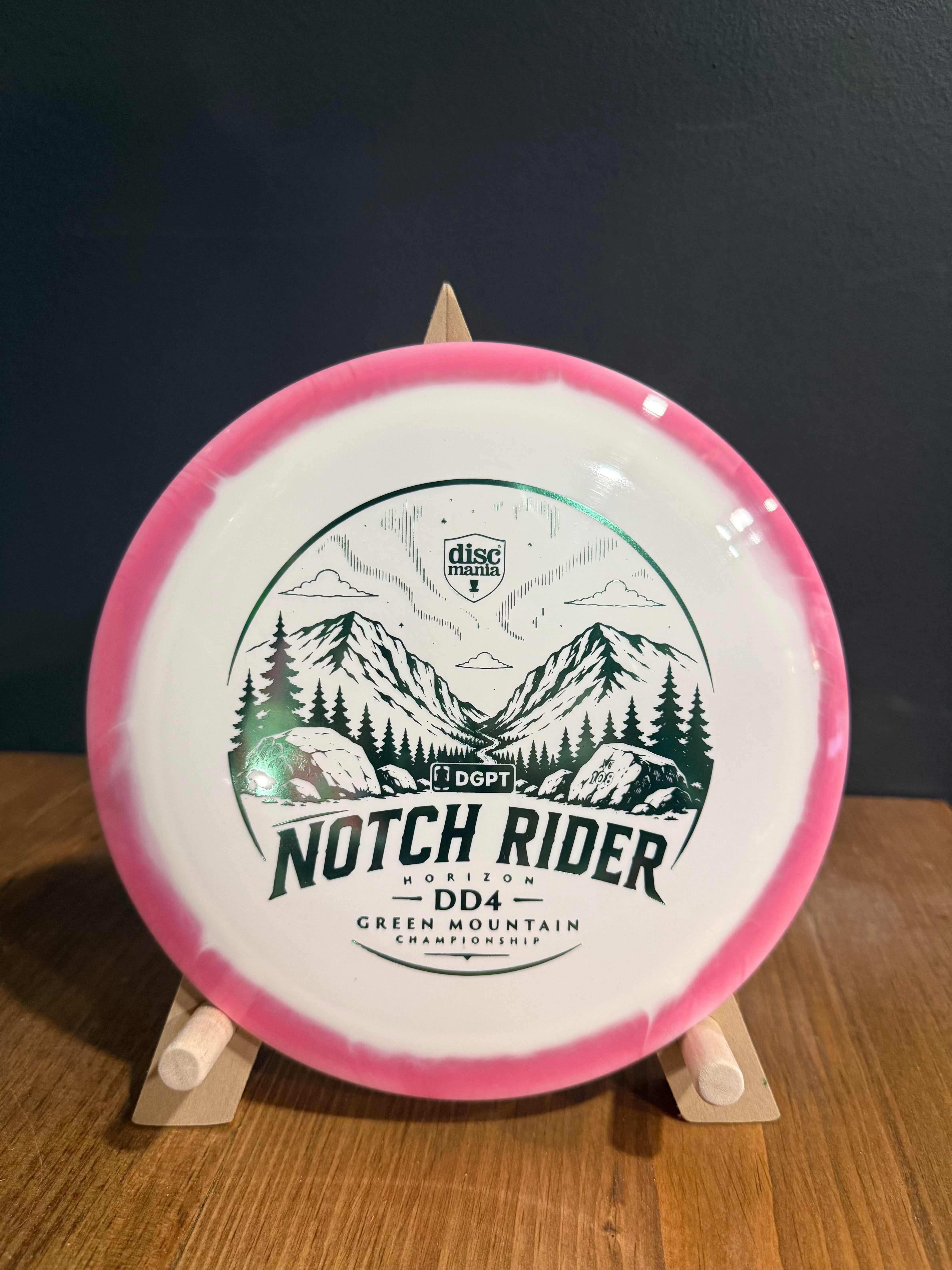Notch Rider DD4 disc golf driver in white and pink Horizon S-Line plastic, with mountain tournament stamp pattern