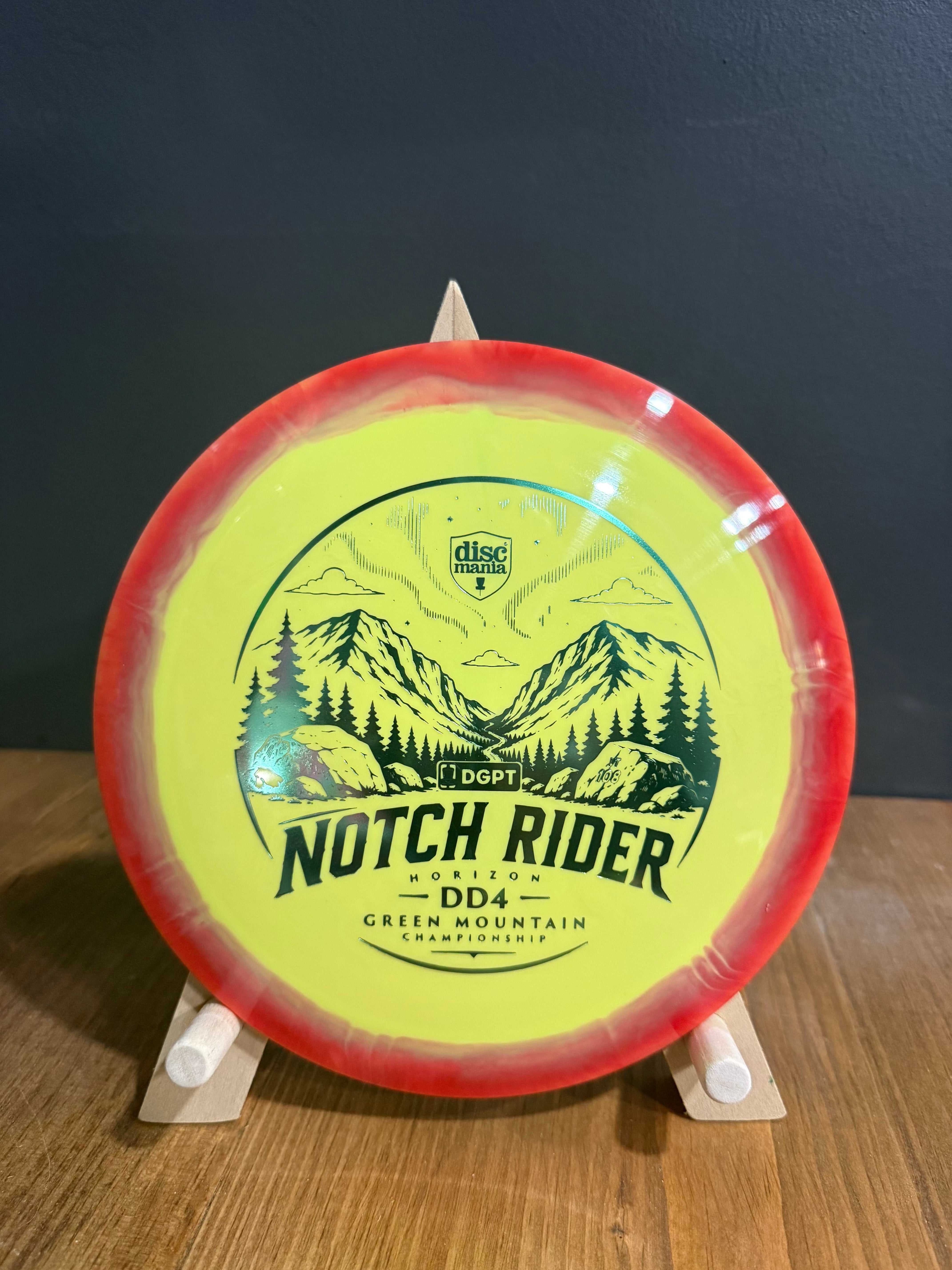 Notch Rider Horizon S-Line DD4 disc golf driver, neon yellow with red rim and mountain fundraiser graphic
