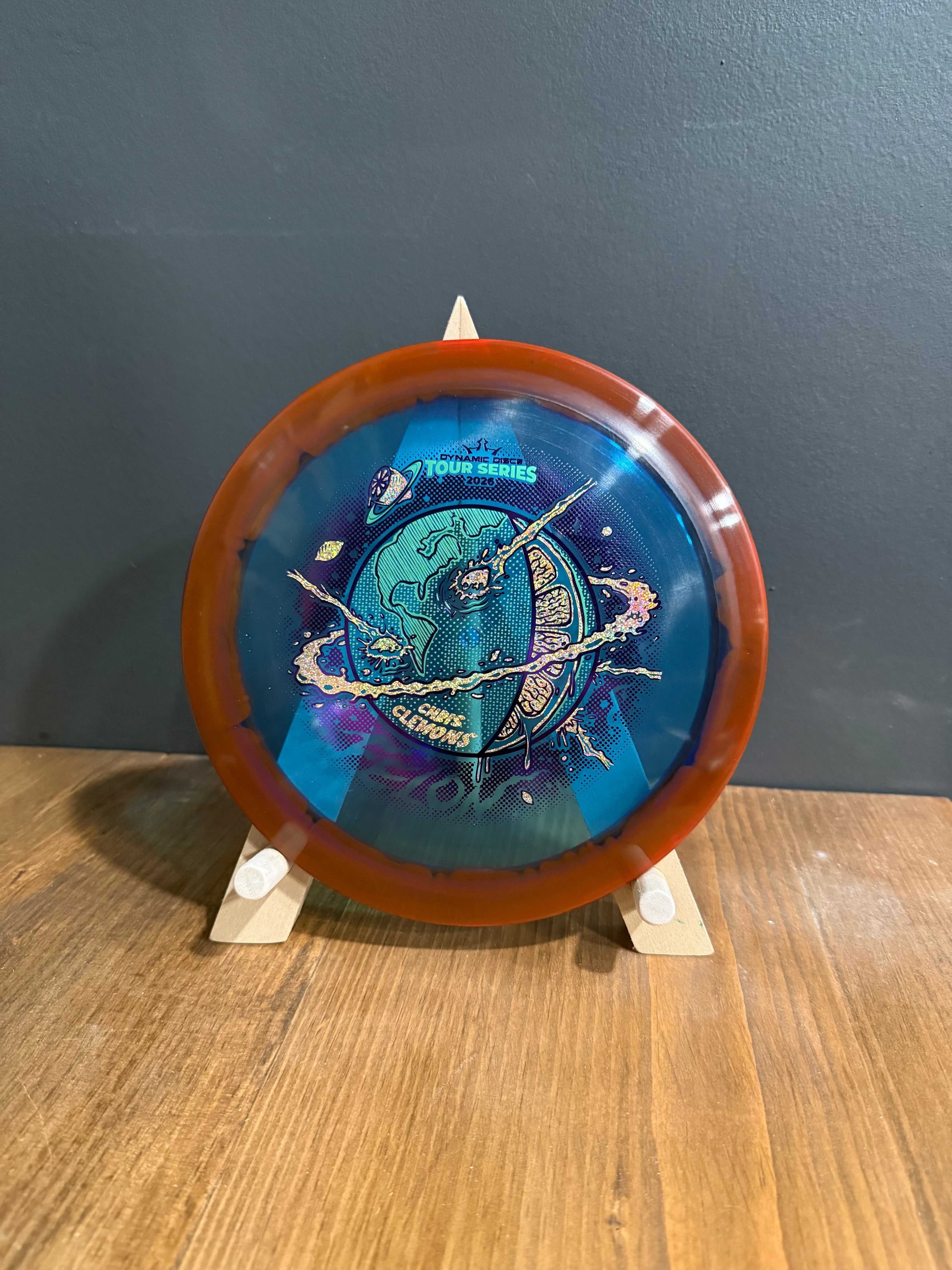 Lucid-X Orbit Felon translucent orange disc with blue cosmic tour series artwork and planetary graphic center