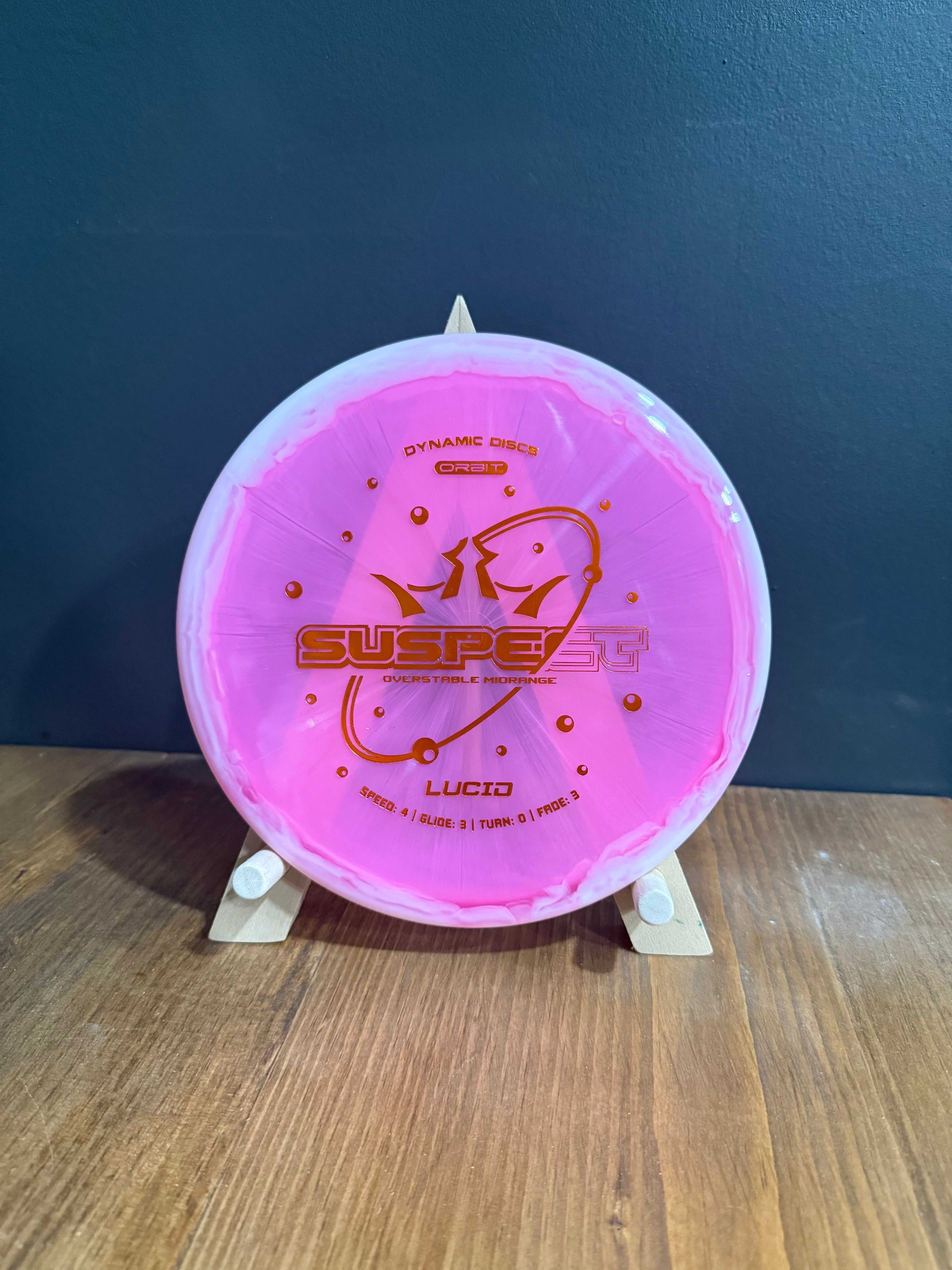 Lucid Orbit Suspect disc in translucent pink plastic with metallic gold orbit-themed stamp and low-profile design