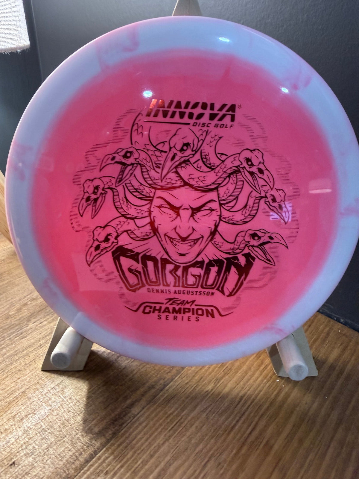 Halo Star Gorgon disc golf distance driver in pink Halo Star plastic with blue rim and Medusa artwork
